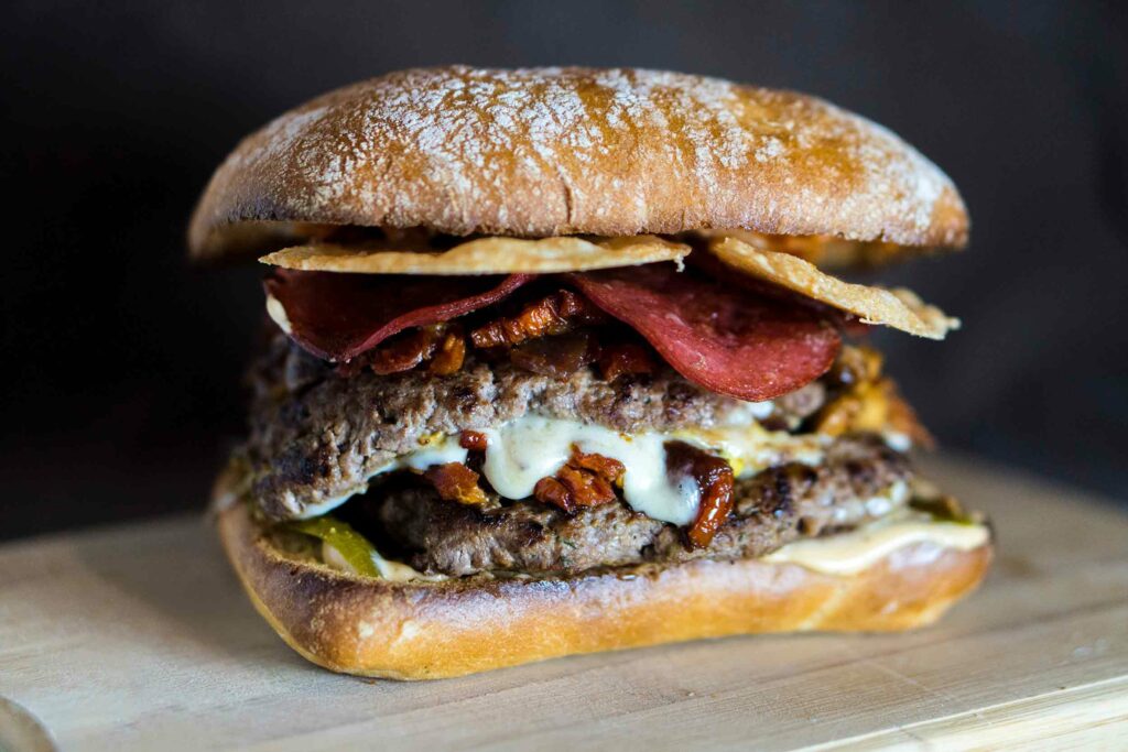 Ein herzhafter Burger mit Hackfleisch, Bacon und Käse als Beispiel für den typischen Umami-Geschmack